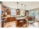 A full kitchen with wood cabinets, granite countertops, island with stools, and a dining area at 2872 Dreamcatcher Loop, Castle Rock, CO 80109