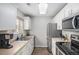 Bright kitchen features stainless steel appliances, white cabinets and plenty of counter space at 15107 E Wesley Ave, Aurora, CO 80014