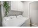 Convenient laundry room with cabinets and overhead shelving for storage at 15107 E Wesley Ave, Aurora, CO 80014