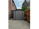 Backyard shed with a brick wall, wood fence, and concrete slab at 15107 E Wesley Ave, Aurora, CO 80014