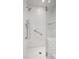 Bright bathroom featuring a large, tiled shower with glass door and stainless grab bar for safety at 210 S High St, Denver, CO 80209