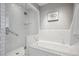 Bathroom featuring a jacuzzi tub, a glass-enclosed shower, and white subway tile at 210 S High St, Denver, CO 80209