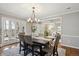 Chic dining room featuring hardwood floors, a modern chandelier, and views into the living room and outdoor space at 210 S High St, Denver, CO 80209