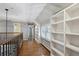 Upstairs hallway boasts hardwood floors, a custom built-in bookshelf, and natural light from the window at 210 S High St, Denver, CO 80209