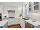 Stylish kitchen with white cabinetry, stainless steel appliances, a mosaic backsplash, and hardwood floors at 210 S High St, Denver, CO 80209