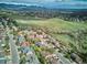 Sweeping aerial view capturing a vibrant neighborhood surrounded by green fields and distant mountains, showcasing community charm at 14072 W Alaska Dr, Lakewood, CO 80228