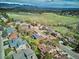 Expansive aerial view highlighting the property's location amidst green spaces and distant mountain views at 14072 W Alaska Dr, Lakewood, CO 80228