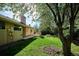 A beautiful backyard featuring a well-kept lawn, a charming patio area, and mature trees providing ample shade at 14072 W Alaska Dr, Lakewood, CO 80228