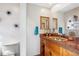 Unique bathroom featuring decorative wall art, wooden cabinets, and an artistic sink at 14072 W Alaska Dr, Lakewood, CO 80228
