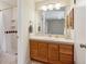 Well-lit bathroom with a wooden vanity, ample storage, and a shower with tile surround at 14072 W Alaska Dr, Lakewood, CO 80228