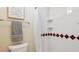 The bathroom features a shower with white tile, red accents, and a towel rack and grey towel at 14072 W Alaska Dr, Lakewood, CO 80228