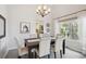 Elegant dining room with a dark wood table, upholstered chairs, contemporary chandelier, and natural light at 14072 W Alaska Dr, Lakewood, CO 80228