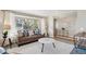 Comfortable living room featuring a large window, plush sofa, modern coffee table, and stylish decor at 14072 W Alaska Dr, Lakewood, CO 80228