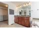 Bathroom featuring dual sinks, a large mirror, and access to walk-in closet at 651 Tiger Lily Way, Highlands Ranch, CO 80126