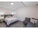 Bedroom boasts a gray upholstered bed, gray couch and light gray wooden floors at 651 Tiger Lily Way, Highlands Ranch, CO 80126
