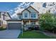 Inviting two-story home featuring a covered porch, well-kept lawn, and an attached two car garage at 651 Tiger Lily Way, Highlands Ranch, CO 80126