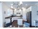 Contemporary white kitchen with stainless appliances, granite counters, and a unique lighting fixture at 651 Tiger Lily Way, Highlands Ranch, CO 80126