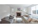 Living room featuring a stone fireplace, neutral tones, and bright, natural light at 651 Tiger Lily Way, Highlands Ranch, CO 80126