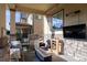 Covered patio with outdoor kitchen, grill, TV, firepit and comfortable seating at 651 Tiger Lily Way, Highlands Ranch, CO 80126