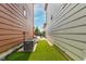 A view of the backyard between two homes that leads to a seating area and artificial grass at 1928 W 67Th Pl, Denver, CO 80221