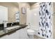 Bathroom featuring granite countertop, white vanity, and a shower and tub at 1928 W 67Th Pl, Denver, CO 80221