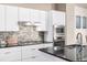 Stylish kitchen with white cabinets, stainless steel appliances, and mosaic backsplash, creating a modern culinary space at 1928 W 67Th Pl, Denver, CO 80221