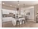 Bright and modern kitchen with an island breakfast bar, stainless steel appliances, and sleek white cabinets at 1928 W 67Th Pl, Denver, CO 80221