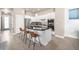 Open kitchen featuring white cabinets, stainless steel appliances, and a sleek breakfast bar with seating at 1928 W 67Th Pl, Denver, CO 80221