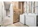 Unfinished basement laundry area, featuring washer and dryer hookups near the finished recreational room at 1928 W 67Th Pl, Denver, CO 80221