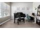 Bright living space featuring a grand piano, modern desk area, and large window with natural light at 1928 W 67Th Pl, Denver, CO 80221