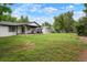 Expansive backyard with a covered patio, lush lawn, and mature trees providing ample shade and privacy at 8595 S Yarrow St, Littleton, CO 80128