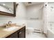 Bright bathroom features a tub/shower, brushed nickel finishes and wainscotting at 8595 S Yarrow St, Littleton, CO 80128
