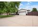 Exterior view highlighting ample parking with a wide driveway and attached two-car garage at 8595 S Yarrow St, Littleton, CO 80128