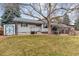 Large backyard with a covered patio, mature trees, and a shed for storage at 7484 E Mercer Pl, Denver, CO 80237