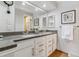 Bright bathroom with dual sinks, granite countertops, and modern fixtures at 7484 E Mercer Pl, Denver, CO 80237