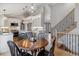 Kitchen and Dining area with gray island, stainless steel appliances, dining table, and stair access at 7484 E Mercer Pl, Denver, CO 80237