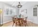 Cozy dining area with hardwood floors, a modern light fixture, and a large window overlooking the yard at 7484 E Mercer Pl, Denver, CO 80237