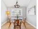 Bright dining room with a modern chandelier and a wooden table set for four with a floral arrangement at 7484 E Mercer Pl, Denver, CO 80237