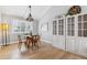 Dining room featuring hardwood floors, a modern light fixture, and a large display cabinet at 7484 E Mercer Pl, Denver, CO 80237