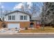 Charming two-story home with a brick facade, attached garage, and inviting front entrance at 7484 E Mercer Pl, Denver, CO 80237