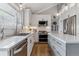 Modern kitchen with stainless steel appliances, white cabinets, subway tile backsplash and hardwood floors at 7484 E Mercer Pl, Denver, CO 80237