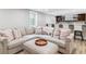 Inviting living room featuring a large sectional sofa, ottoman, and a stylish wet bar in background at 7484 E Mercer Pl, Denver, CO 80237