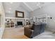 Cozy living room with a stone fireplace, built-in bookshelves, neutral carpet, and comfortable leather seating at 7484 E Mercer Pl, Denver, CO 80237