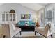 Cozy living room features bright furniture, eye-catching artwork, and natural light from large windows at 7484 E Mercer Pl, Denver, CO 80237