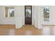 Welcoming entryway featuring a dark wood front door, light wood floors, and windows offering scenic views at 5035 Vermillion Dr, Castle Rock, CO 80108