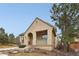 Charming home with an arched entry and tile roof; set against a backdrop of mature trees and blue sky at 5035 Vermillion Dr, Castle Rock, CO 80108