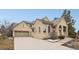 Stucco exterior featuring a tile roof, three car garage, and manicured landscaping around the home at 5035 Vermillion Dr, Castle Rock, CO 80108