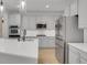 Open kitchen with stainless appliances, white cabinets, and a large island overlooking the living area at 5035 Vermillion Dr, Castle Rock, CO 80108