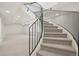 Elegant curved staircase with iron railing leading to a spacious, carpeted living area at 5035 Vermillion Dr, Castle Rock, CO 80108