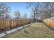 Fenced backyard with mature trees, grassy area, and a swing set, perfect for outdoor activities at 2436 W 34Th Ave, Denver, CO 80211